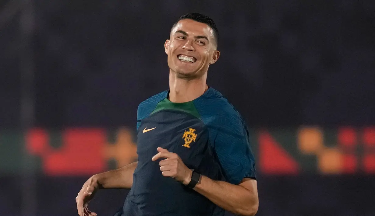 Cristiano Ronaldo tersenyum saat melakukan pemanasan saat latihan resmi Portugal menjelang pertandingan sepak bola Piala Dunia grup H antara Portugal dan Ghana di tempat pelatihan Al Shahaniya SC, Al Shahaniya, Qatar, Rabu (23/11/2022). Situasi yang menimpa Ronaldo dikhawatirkan mempengaruhi performa pemain dengan sebutan CR7 tersebut. (AP Photo/Lee Jin-man)