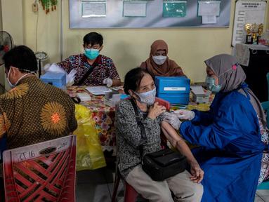 Warga menerima dosis vaksin booster COVID-19 Pfizer di Surabaya, Jawa Timur, Kamis (13/1/2022). (JUNI KRISWANTO/AFP)