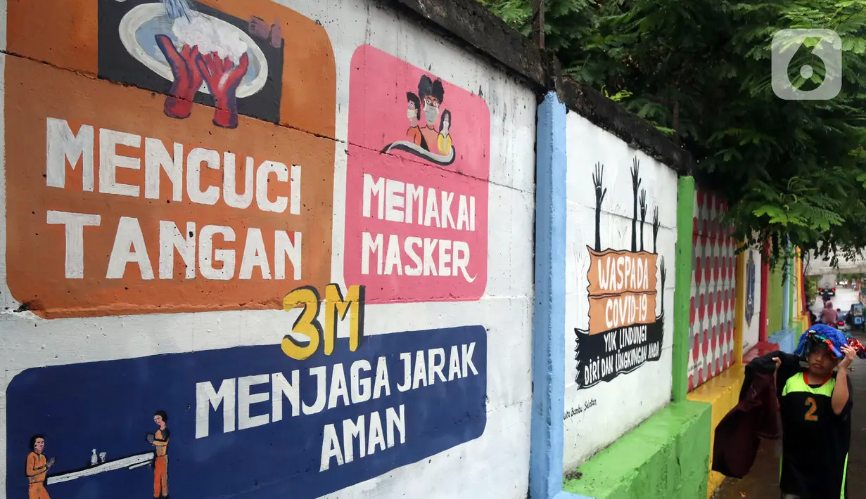 Warga melintas di depan mural yang berisi pesan 3M di Jakarta, Rabu (11/11/2020). Mural tersebut dibuat untuk mengingatkan masyarakat agar menerapkan protokol kesehatan saat beraktivitas sehari-hari. (Liputan6.com/Herman Zakharia)