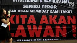 Seorang wanita berdiri di depan poster saat massa dari "Gerakan Rakyat Nusantara Anti Terorisme" atau disingkat "Geranat" melakukan Aksi di depan Gedung MPR/DPR Senayan, Jakarta, Rabu (16/5). (Liputan6.com/JohanTallo)