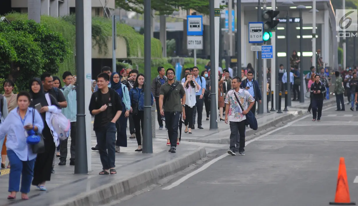 Sejumlah karyawan terpaksa berjalan kaki usai pulang kerja di kawasan Thamrin, Jakarta, Selasa (21/5). Akibat adanya aksi masa tolak hasil pemilu 2019 membuat sejumlah ruas jalan di kawasan tersebut di tutup. (Liputan6.com/Angga Yuniar)