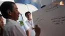Jokowi menuliskan komentar setelah mencoba sensasi diatas monorel.(Liputan6.com/Herman Zakharia)
