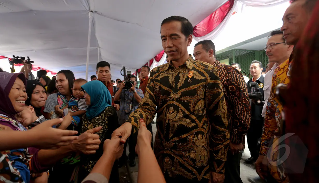 Presiden Jokowi saat pembagian Kartu Indonesia Sehat (KIS), Kartu Indonesia Pintar dan Kartu Keluarga Sejahtera (KKS) kepada masyarakat di Penjaringan, Jakarta, Rabu (13/5/2015). (Liputan6.com/Faizal Fanani)