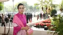 Menteri Keuangan, Sri Mulyani tampil dengan atasan baju kurung warna fuschia. Dipadukan selendang dan kain bawahan warna pink yang serasi dengan tasnya. [@smindrawati]