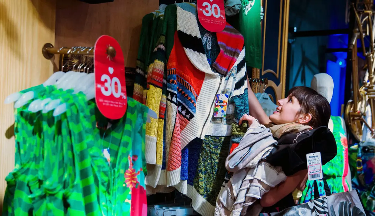 Salah satu pelanggan wanita terlihat bersemangat memilih dan mendapatkan pakaian secara gratis dari gerai Desigual di Berlin, Jerman, (20/6/2014). (REUTERS/Thomas Peter)
