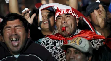 Seorang suporter Peru meniupkan peluit saat menyaksikan pertandingan perempat final Peru melawan Bolivia di Copa America 2015 di pusat kota Lima, Peru, (26/6/2015) dini hari. Peru melangkah ke semifinal usai mengalahkan Bolivia 3-1. (REUTERS/Janine Costa)