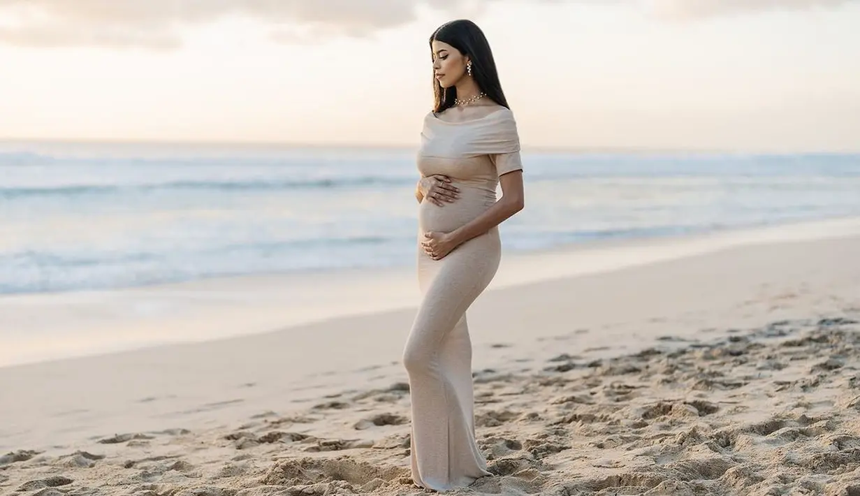 Ia mengenakan knitted dress dengan detail sabrina berwarna cokelat muda sambil pamer baby bump [@jharnabhagwani]