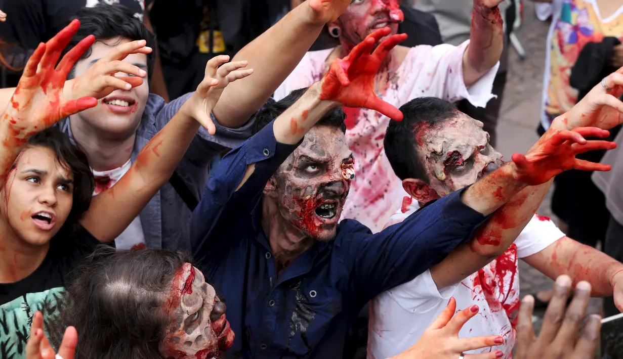 Sejumlah orang berjalan dengan riasan zombie dalam parade "Zombie Walk" di Sao Paulo, Brasil, Senin (2/11/2015). (REUTERS / Paulo Whitaker)