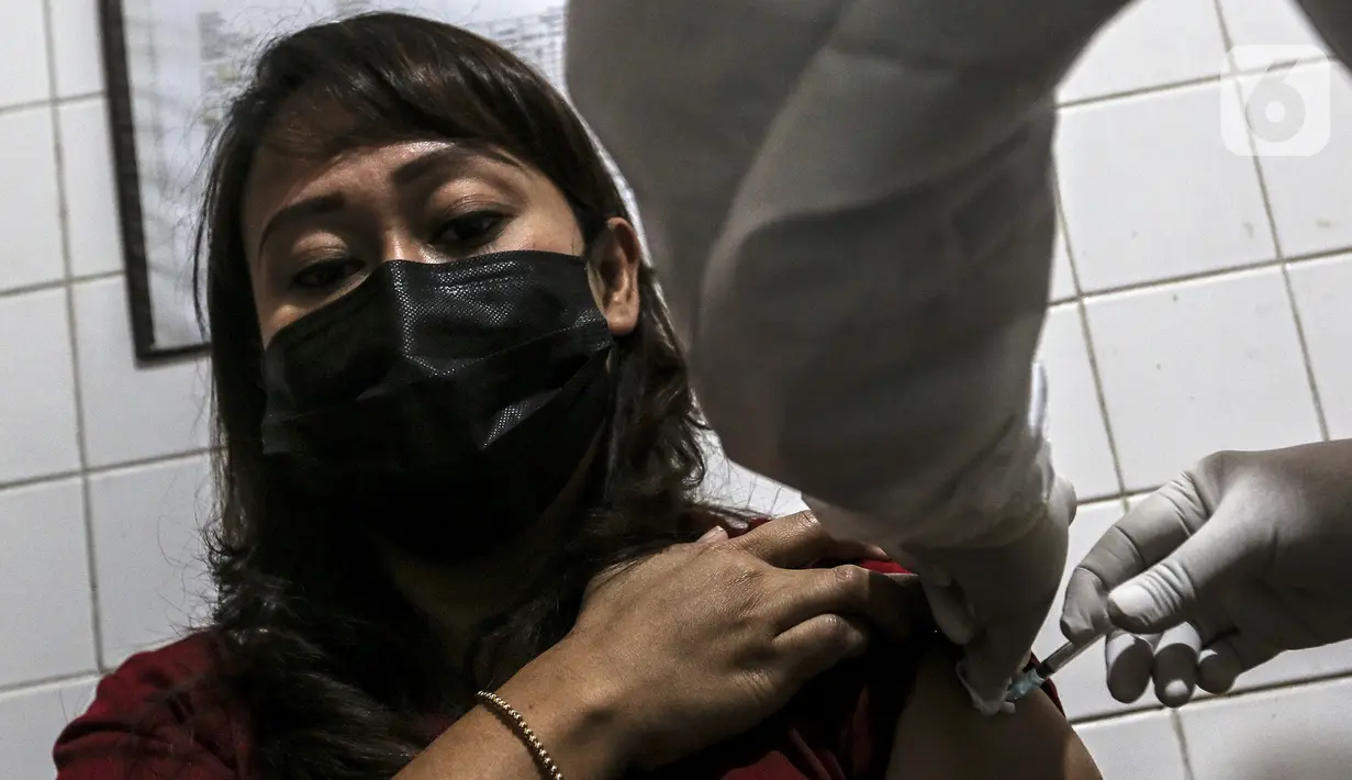 Petugas medis menyuntikkan vaksin COVID-19 Sinovac kepada tenaga kesehatan di Puskesmas Palmerah, Jakarta, Kamis (28/1/2021). Pemberian vaksin COVID-19 tahap kedua dilaksanakan terhadap tenaga kesehatan mulai hari ini. (Liputan6.com/Johan Tallo)
