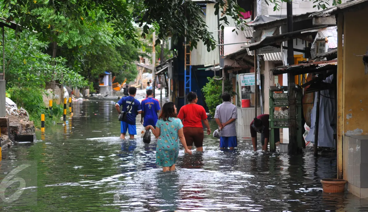 Tampak Warga melawati jalanan yang banjir di kawasan Jakarta Barat, Jumat (26/2). Ketinggian banjir mencapai 50-60cm.  (Liputan6.com/Faisal R Syam)