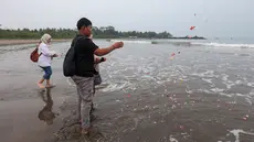 Keluarga menaburkan bunga ke laut dalam prosesi untuk lima jurnalis dan tiga kru kapal Arupadhatu 1 di pantai dekat Dermaga Pegedongan, Banten, Jumat (18/9/2026). Dermaga tersebut menjadi titik awal keberangkatan delapan orang itu pada Senin (7/9/2026). (KLY/Budy Santoso)