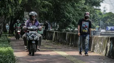 Sejumlah pengendara motor melintas di atas trotoar pejalan kaki di kawasaan Daan Mogot, Jakarta, Senin (26/4/2021). Padatnya volume kendaraan pada jam kerja di kawasan itu membuat sejumlah pengendara motor nekat menggunakan trotoar yang merupakan
hak bagi pejalan kaki. (Liputan6.com/Faizal Fanani)