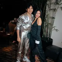 Berpose bersama sang kekasih, Shenina tampil cantik dengan outfit unik, stripes-top berdetail halter-neck dan celana panjang yang senada. Ia padukan dengan sneakers favoritnya yang berwarna hitam-putih. Foto: Instagram.