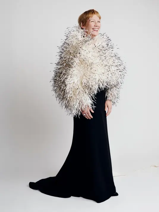 Sandra Hüller tampil mencuri perhatian lewat kombinasi gaun hitam simpel dengan oversized feather cape bernuansa putih dan hitam. Look ini menghadirkan drama khas red carpet Cannes tanpa kehilangan kesan elegan. [Dok/Chanel].