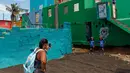 Turis mengambil gambar dua anak kecil saat mengunjungi lokasi syuting video Despacito di La Perla, San Juan, Puerto Rico, 22 Juli 2017. Lagu Despacito berhasil mencetak rekor video musik bahasa Spanyol yang paling banyak ditonton. (Ricardo ARDUENGO/AFP)