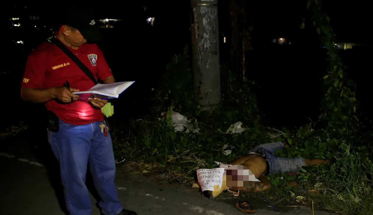 Petugas mendata jenazah pria di sebuah jalan di kota Pasay, metro Manila, Filipina (17/11). Belakangan, banyak korban yang merupakan pecandu dan bandar di Filipina tewas dalam kondisi mengenaskan. (Reuters/Romeo Ranoco)