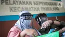 Petugas menggunakan face shield saat melayani masyarakat Dinas Kependudukan Kecamatan Pamulang, Tangerang Selatan, Jumat (29/5/2020).  Penggunaan Face Shield tersebut sebagai salah satu upaya untuk melindungi diri dalam penyebaran COVID-19. (Liputan6.com/Faizal Fanani)