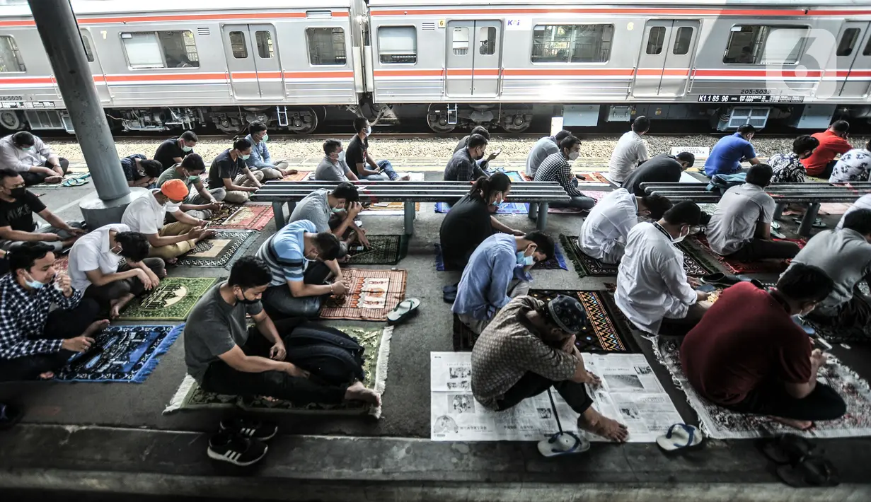 Kereta commuter line melintas dekat jemaah yang tengah salat Jumat di Stasiun Kampung Bandan, Jakarta, Jumat (7/5/2021). Jemaah Masjid Al-Hidayah salat Jumat di Stasiun Kampung Bandan karena keterbatasan lahan, terlebih jumlah meningkat di saat Ramadan. (merdeka.com/Iqbal S. Nugroho)