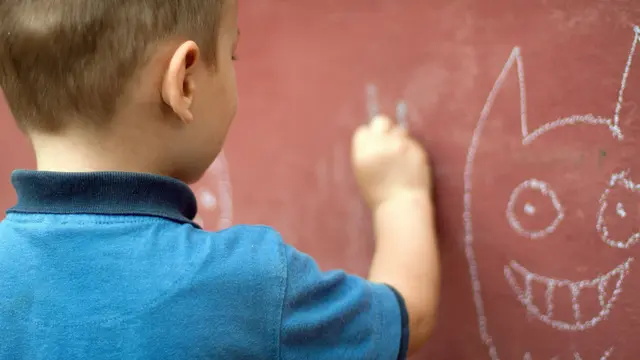 Anak sedang menggambar di dinding