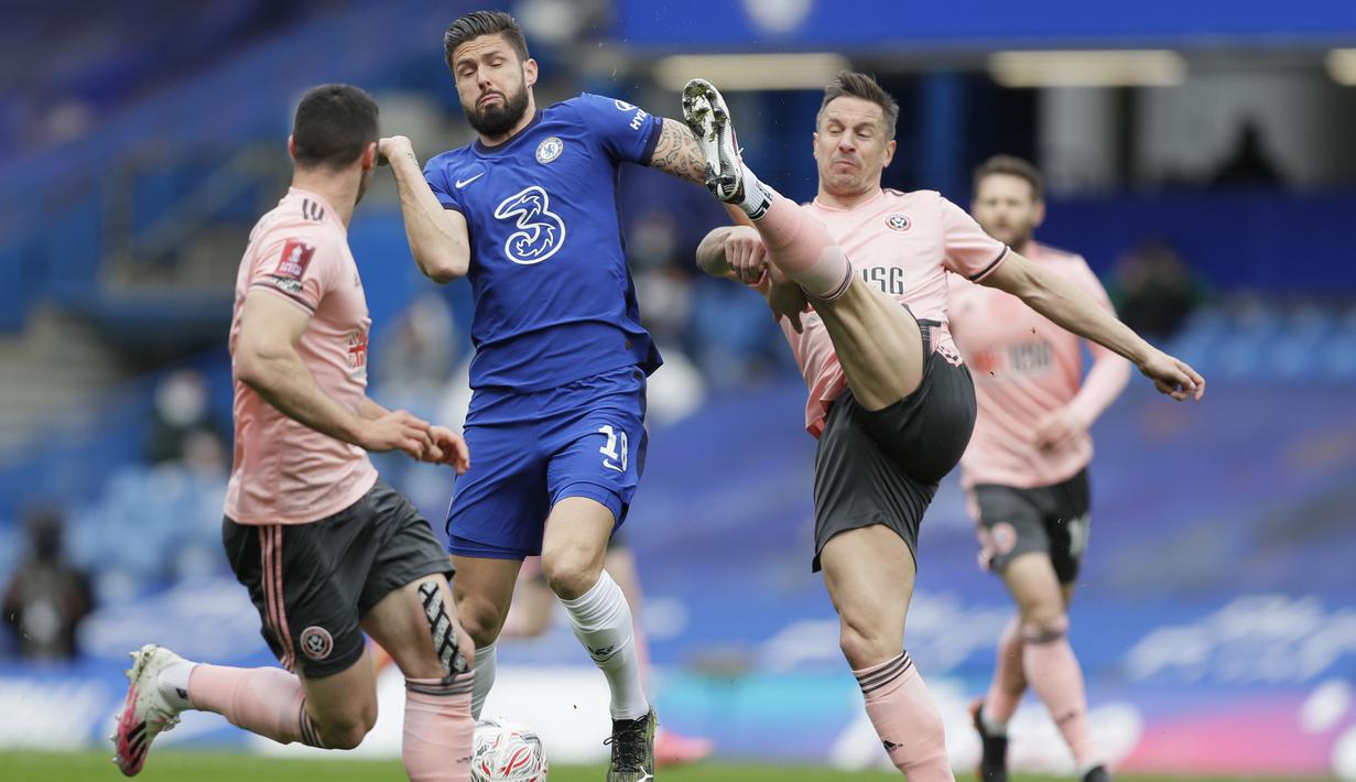 Striker Chelsea, Olivier Giroud (tengah) berebut bola dengan bek Sheffield United, Phil Jagieka dalam laga perempatfinal Piala FA 2020/2021 di Stamford Bridge, London, Minggu (21/3/2021). Chelsea menang 2-0 atas Sheffield United. (AP/Kirsty Wigglesworth)