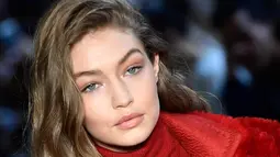 Ekspresi Gigi Hadid saat membawakan busana karya Max Mara selama Autumn / Winter 2017 di Milan Fashion Week, Italia (23/2). Gigi Hadid tampil cantik dan seksi dengan busana tipis berwarna merah. (AFP Photo / Miguel Medina)