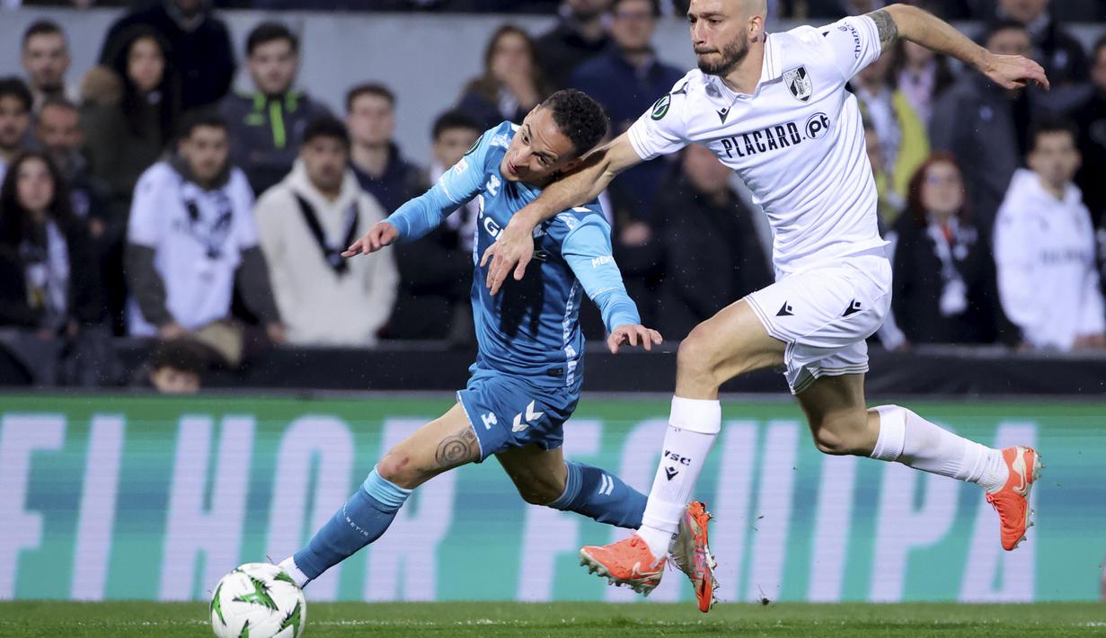 Pemain Real Betis, Antony (kiri) berebut bola dengan pemain Vitoria Guimaraes, Tomas Ribeiro dalam laga leg 2 babak 16 besar Conference League yang berlangsung di D Afonso Henriques Stadium, Portugal, Jumat (14/03/2025) dini hari WIB. (AP Photo/Luis Vieira)