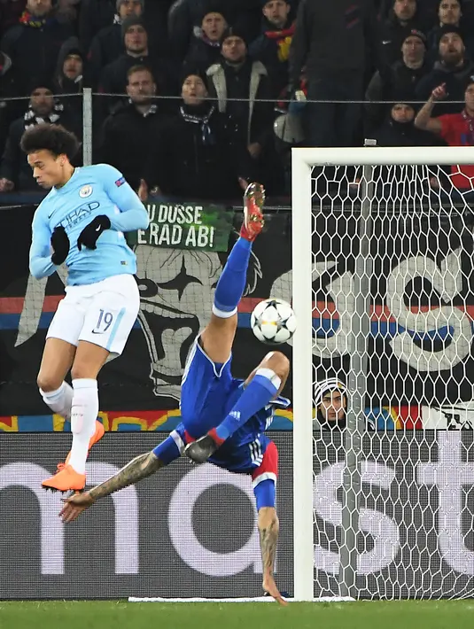 Gelandang Manchester City, Leroy Sane berebut bola dengan pemain FC Basel, Leo Lacroix pada leg pertama babak 16 besar Liga Champions di St. Jakob Park, Rabu (14/2). Manchester City mencukur FC Basel dengan empat gol tanpa balas. (Patrick HERTZOG/AFP)