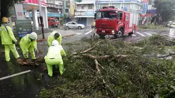 Pemadam kebakaran memidahkan pohon dijalan akibat angin kencang Topan Soudelor di Taipei, Taiwan, (8/8/2015). Empat orang tewas akibat peristiwa angin kencang Topan Soudelor dan hujan deras.  (REUTERS/Pichi Chuang)