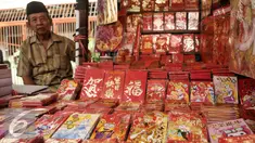Pedagang angpao menunggu pembeli di kawasan Petak Sembilan, Jakarta, Senin (23/1). Jelang hari raya Imlek 2017 pedagang angpao dan pernak-pernik mulai ramai di kawasan Petak Sembilan. (Liputan6.com/Yoppy Renato)