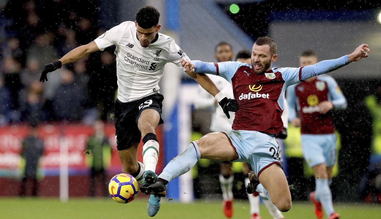Pemain Liverpool, Dominic Solanke (kiri) berebut bola dengan pemain Burnley, Phil Bardsley pada lanjutan Premier League di Turf Moor, Burnley, (1/1/2018). Liverpool menang 2-1 atas Burnley. (Martin Rickett/PA via AP)