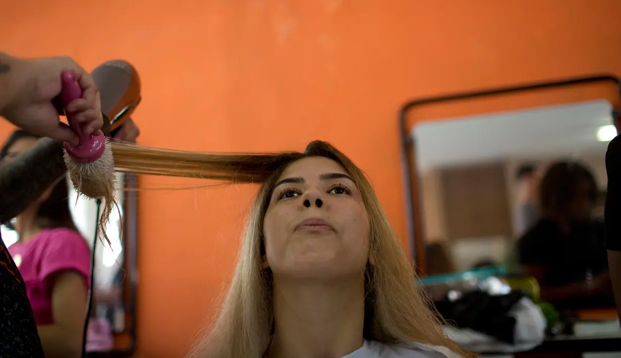 Seorang narapidana melakukan persiapan untuk  berkompetisi dalam kontes kecantikan Miss Talavera Bruce 2018 di Rio de Janeiro, Brasil, Selasa (4/12). Kontes ini digelar di penjara khusus perempuan dengan keamanan maksimum. (AP/Silvia Izquierdo)