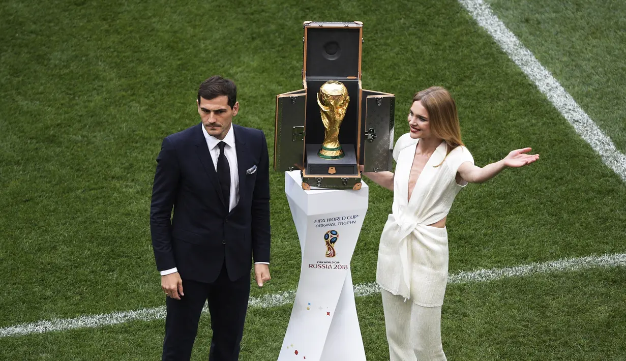 Mantan kiper timnas Spanyol, Iker Casillas dan supermodel Rusia, Natalia Vodianova berdiri di samping trofi Piala Dunia 2018 sebelum laga pembuka di stadion Luzhniki, Kamis (14/6). Trofi disimpan dalam kotak yang didesain Luis Vuitton (AFP/Mladen ANTONOV)
