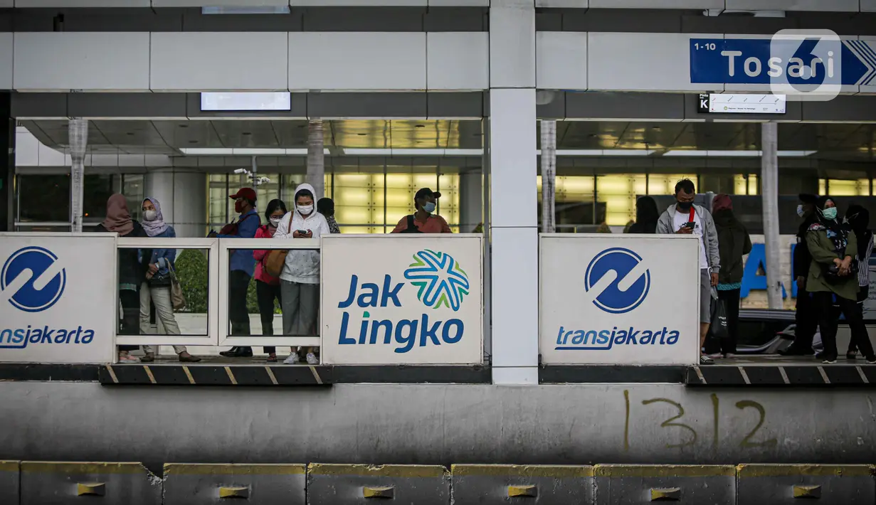 Sejumlah pekerja menunggu Bus Transjakarta di kawasan Jalan Sudirman, Jakarta, Selasa (2/11/2021). Sektor non-esensial kini boleh mempekerjakan hingga 75 persen karyawannya dari kantor. Sebelumnya, angka ini dibatasi hingga 50 persen. (Liputan6.com/Faizal Fanani)