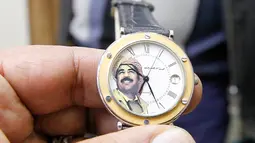 Seorang penjual menunjukan jam tangan yang bergambar mantan Presiden Irak, Saddam Hussein di Baghdad, Irak (28/12). Pada 5 November 2006 Hakim Ketua Rauf Rasheed Abdel Rahman menjatuhkan hukuman mati kepada Saddam Hussein. (AFP/Sabah Arar)