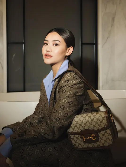 Aaliyah Massaid tampil elegan di salah satu photoshoot dengan luxury brand. Ia padukan kemeja biru dengan blazer dan celana bermotif logo brand. [Foto: Instagram/aaliyah.massaid]