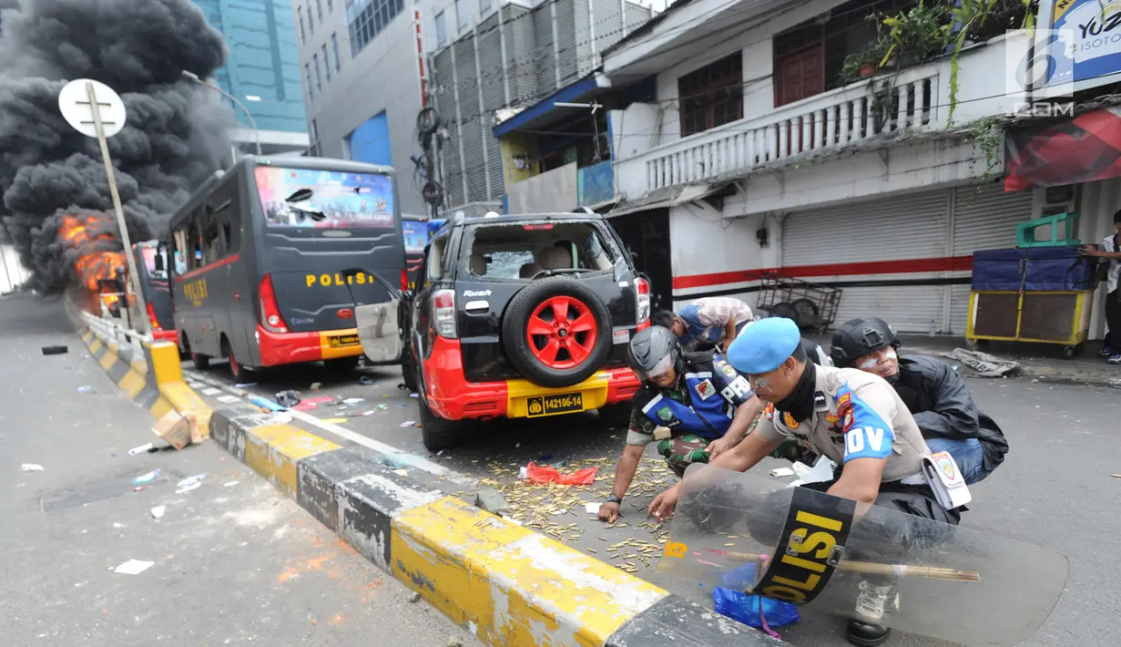 Warga, Polisi dan TNI mengambil peluru setelah kendaraan Polisi terbakar di Jalan Brigjen Katamso, Slipi, Jakarta, Rabu (22/5/2019). Belum diketahui penyebab terbakarnya dua bus yang terparkir bersama bus polisi lainnya dilokasi tersebut. (merdeka.com/Arie Basuki)