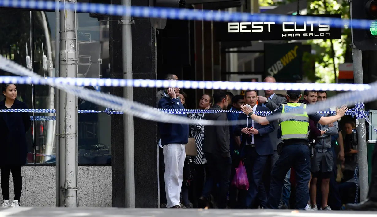 Petugas kepolisian melarang sejumlah orang mendekati lokasi dimana sebuah mobil menghantam para pejalan kaki di pusat kota Melbourne, Australia, Jumat (20/1). Tiga orang tewas dan 20 orang lainnya luka-luka dalam insiden itu. (AP Photo/Andrew Brownbill)