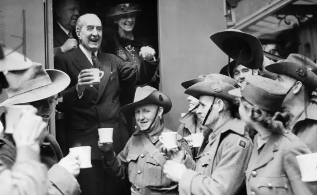 Perdana Menteri Stanley Bruce dari Australia sedang berbagi saat minum teh bersama tentara Australia dari 2nd AIF Division di London, 1940. (Sumber State Library of Victoria)