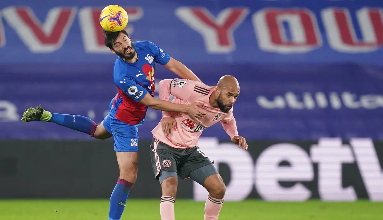 Bek Crystal Palace, James Tomkins (kiri) memenangi duel udara dengan striker Sheffield United, David McGoldrick dalam laga lanjutan Liga Inggris 2020/21 pekan ke-17 di Selhurst Park, Sabtu (2/1/2021). Crystal Palace menang 2-0 atas Sheffield United. (AFP/John Walton/Pool)