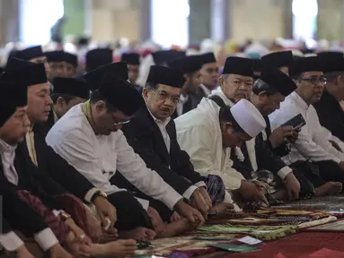 Wakil Presiden Jusuf Kalla (tengah) bersama ribuan umat muslim melakukan salat Idul Fitri di Masjid Istiqlal, Jakarta, Jumat (17/7/2015).  Tampak, Wakil Presiden Jusuf Kalla duduk bersama sejumlah pejabat tinggi negara. (Liputan6.com/Faizal Fanani)