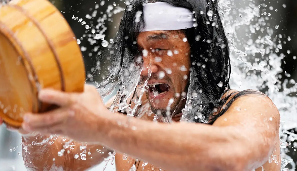 <p>Seorang jemaat yang setengah telanjang menyiram dirinya dengan air dingin saat ritual ketahanan dingin di Kuil Shinto Kanda Myojin, Tokyo, Jepang, Sabtu (14/1/2023). Dalam ritual yang berlangsung selama dua hari dan menjadi bagian dari festival Shinto itu peserta menuangkan air dingin ke tubuh karena diyakini dapat menyucikan jiwa mereka. (AP Photo/Hiro Komae)</p>
