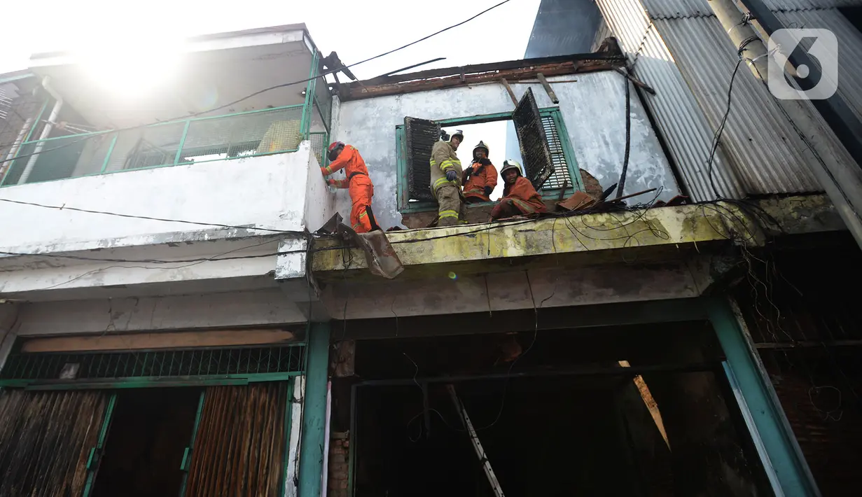 Petugas pemadam kebakaran melakukan pembasahan bioskop Grand Theater yang terbakar di Simpang Lima Senen, Jakarta, Jumat (9/10/2020). Unjuk rasa menentang disahkannya Omnibus Law UU Cipta Kerja berujung aksi anarkis merusak berbagai fasilitas umum pada Kamis malam (8/10). (merdeka.com/Imam Buhori)