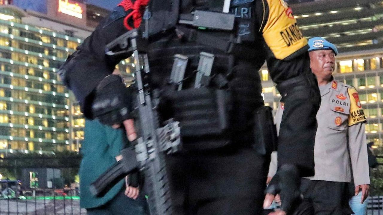 Personel Brimob dengan persenjataan lengkap saat berjaga di Bundaran HI, Jakarta, Minggu (31/12/2023).