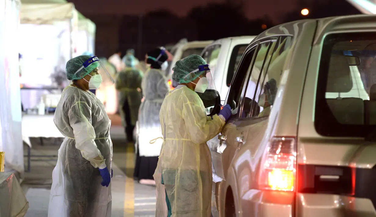 Para petugas medis bersiap mengambil sampel usap dari para pengemudi di pusat tes COVID-19 lantatur (drive-thru) di Kegubernuran Farwaniya, Kuwait, 18 November 2020. Total kasus COVID-19 di Kuwait menjadi 138.337 dan kematian menjadi 857. (Xinhua/Asad)