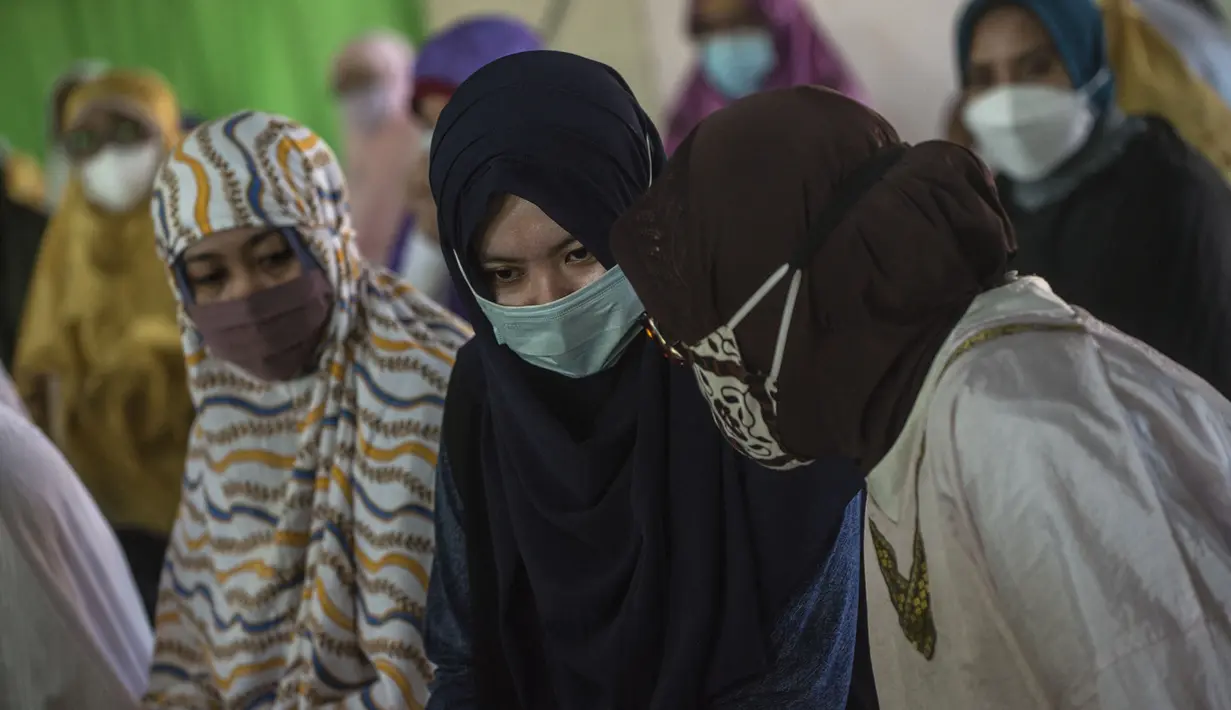 Berda Asmara (tengah), istri dari Serda Mes Guntur Ari Prasetya, berbincang disela doa bersama di Universitas Nahdlatul Ulama Surabaya, Senin (26/4/2021). Sholat ghaib dan doa bersama tersebut untuk mendoakan seluruh kru KRI Nanggala 402 yang tenggelam di perairan Bali. (Juni Kriswanto/AFP)