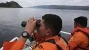 Tim SAR menggunakan teropong saat proses pencarian korban KM Sinar Bangun yang tenggelam di Danau Toba, Sumatra Utara, Rabu (20/6). Hingga hari ketiga, sebanyak 18 penumpang selamat, dua tewas dan 160 lainnya dalam proses pencarian. (AP/Binsar Bakkara)