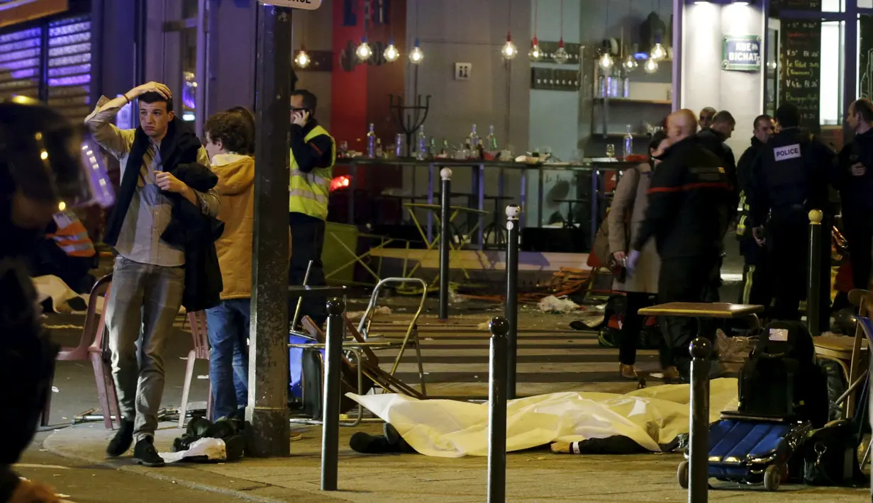 Korban yang tewas dari penembakan dan bom bunuh diri yang dilakukan teroris di Paris ditutupi sebuah kain putih, Perancis, Jumat (13/11/2015). Dikabarkan ada 140 orang tewas dalam aksi teroris tersebut. (Reuters)