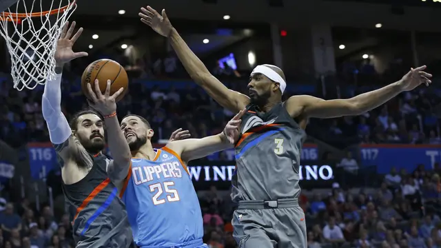 Steven Adams (Kiri) memblok tembakan Austin Rivers