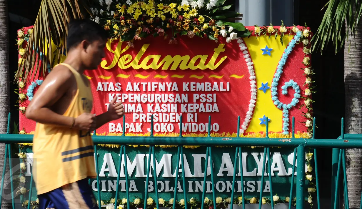 Warga berolahraga lari di depan kantor PSSI di kawasan Stadion Gelora Bung Karno, Jakarta, Sabtu (27/2/2016). Seseorang mengatasnamakan pecinta sepak bola mengirimi ucapan selamat kepada PSSI. (Liputan6.com/Helmi Fithriansyah)