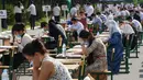 Para siswa Uzbekistan mengikuti ujian masuk luar ruangan, di tengah pandemi COVID-19 yang sedang melanda, di Tashkent pada Rabu (2/9/2020). (Photo by Yuri KORSUNTSEV / AFP)